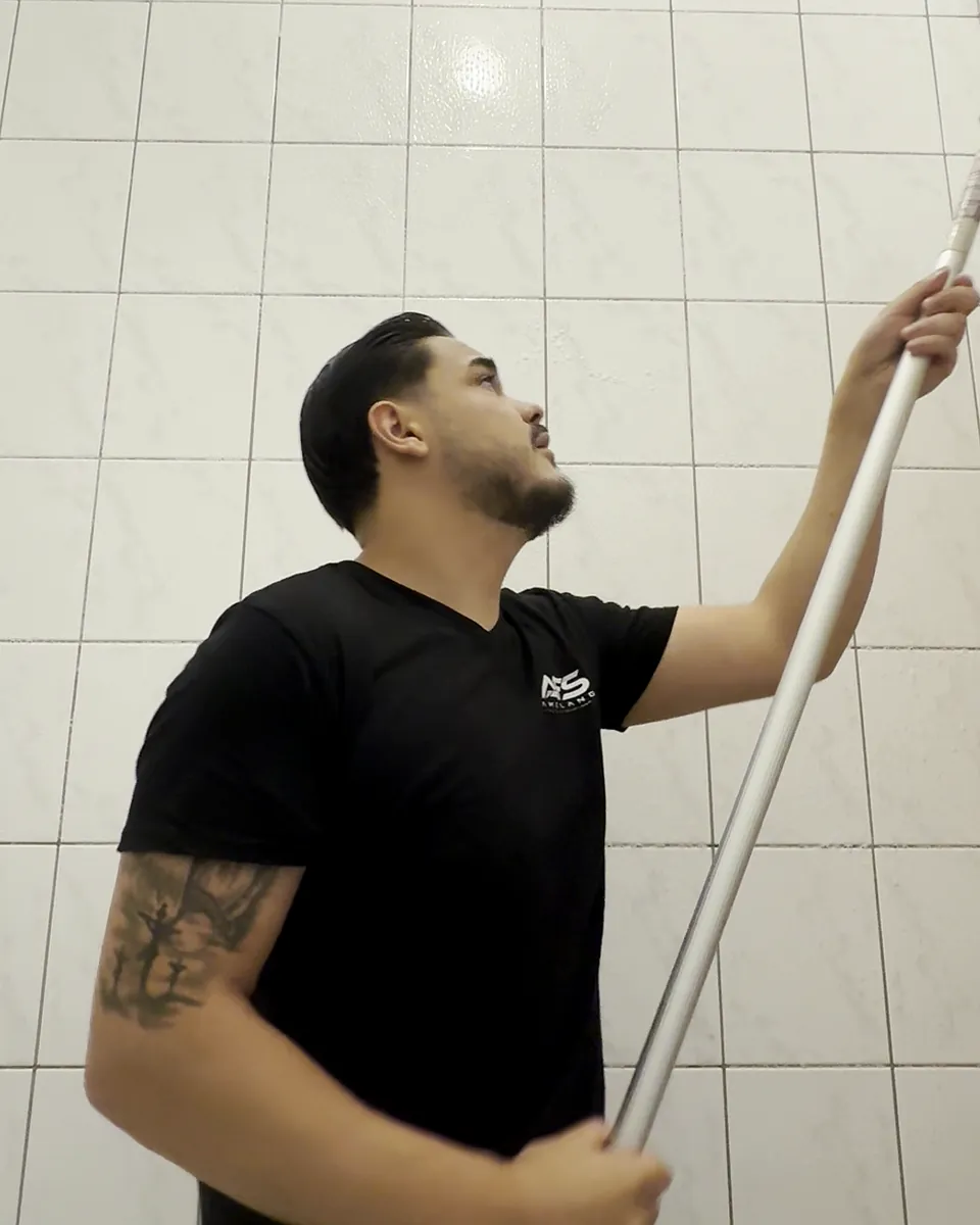 Antonio Leon Amelang, Inhaber von Amelang Facility Solutions, bei der Reinigung einer gefliesten Wand