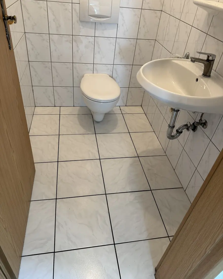 Derselbe WC-Raum nach der Grundreinigung: heller, sauberer Boden